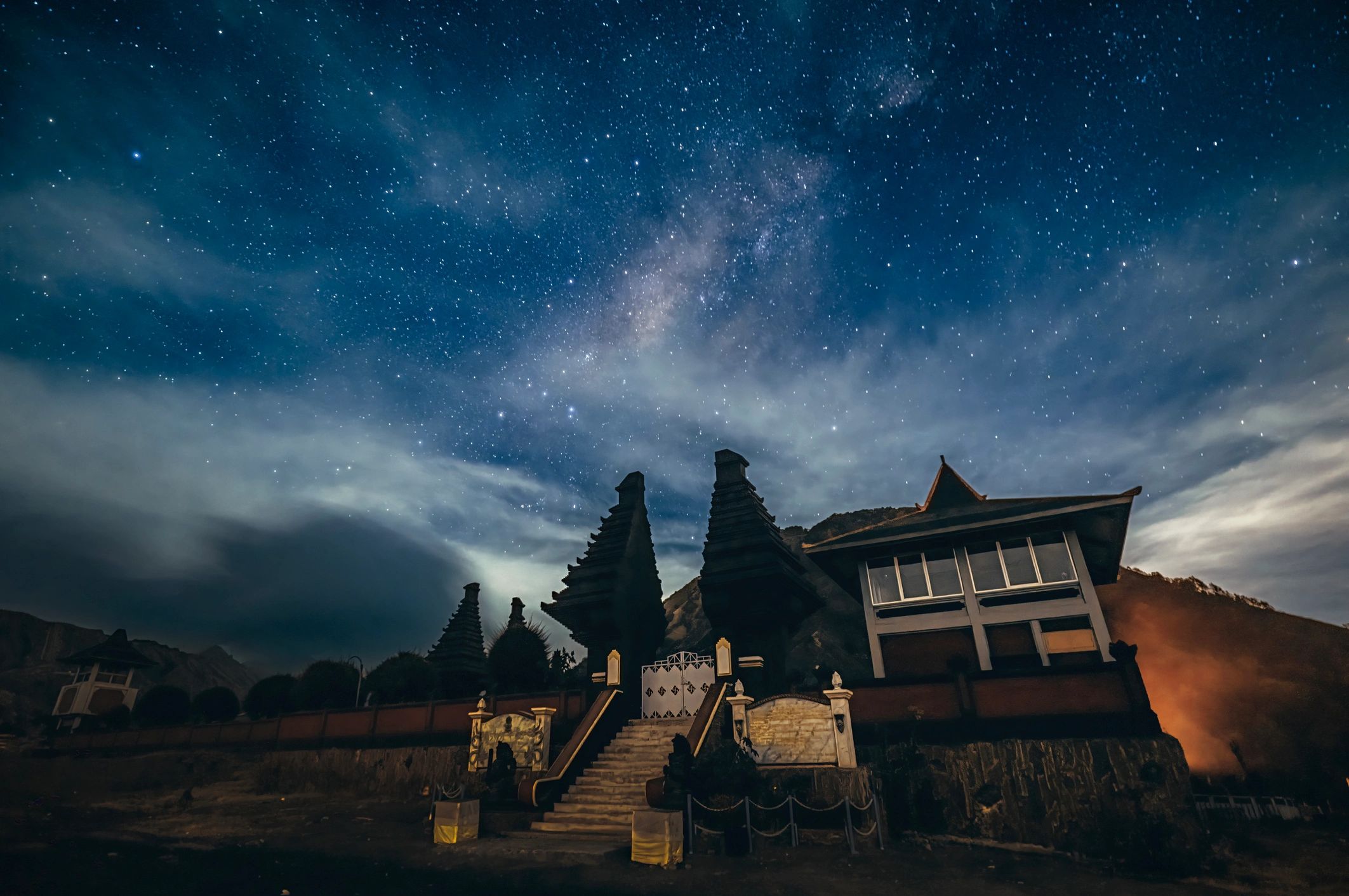 Star-filled night sky above a dramatic landscape